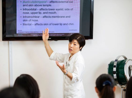 Esthetics Instructor explaining a topic to students in a theory class.