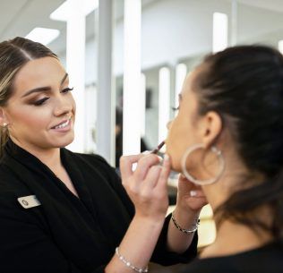 Christine Valmy makeup instructor demonstrating application techniques to a makeup class