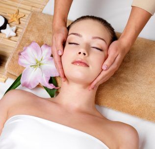 Client laying down on a spa bed after receiving a facial treatment by a professional.