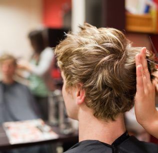 Student barbering a male client's hair