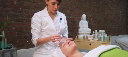 Christine Valmy instructor applying a serum to a student laying down