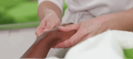 Esthetics student massaging a woman's hand