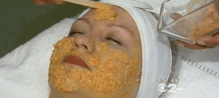 Marina Valmy applies a DIY facial mask to a client laying on a spa treatment bed