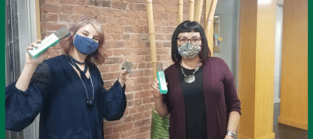 Two women smiling while wearing face masks